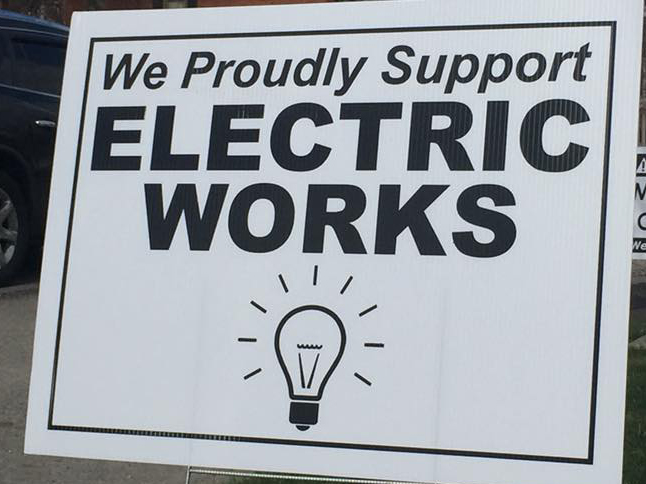 Yard sign reads, "We proudly support Electric Works."