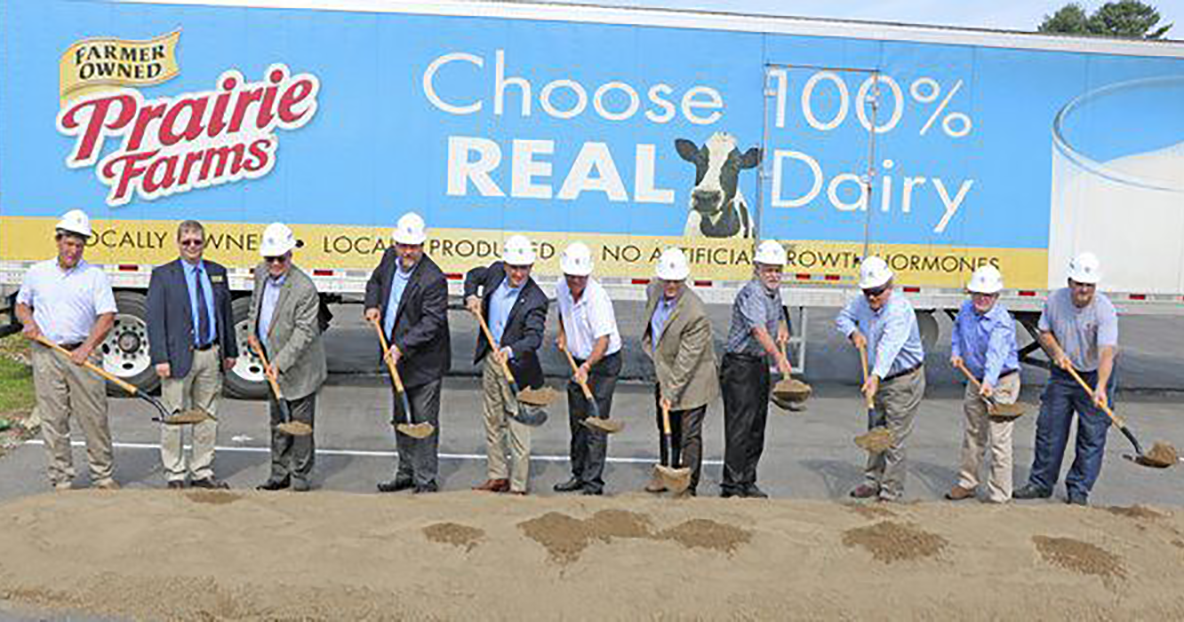 people wearing hard hats participating in a groundbreaking ceremony