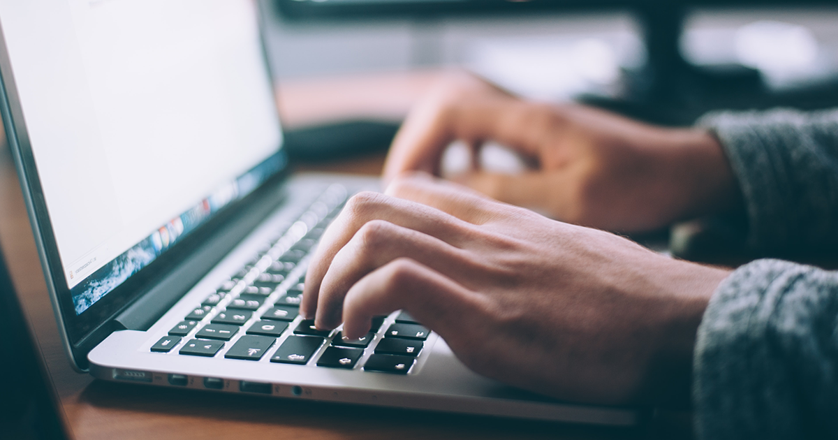 hands typing on a laptop computer