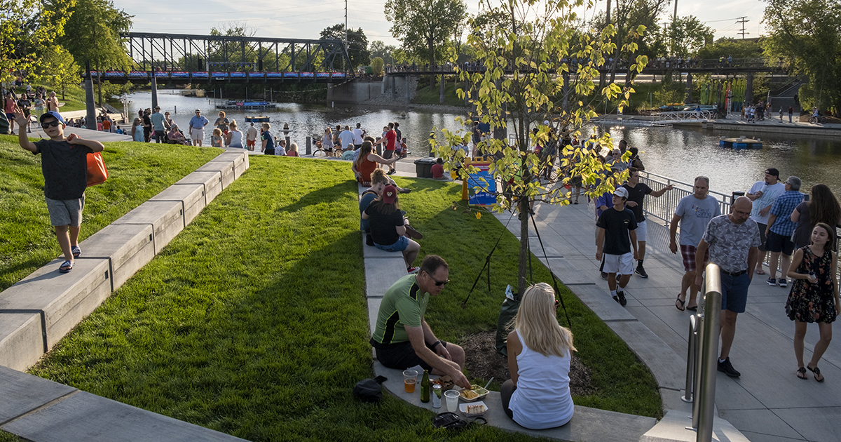 Photo of people walking the sidewalk and sitting on the lawns at Promenade Park