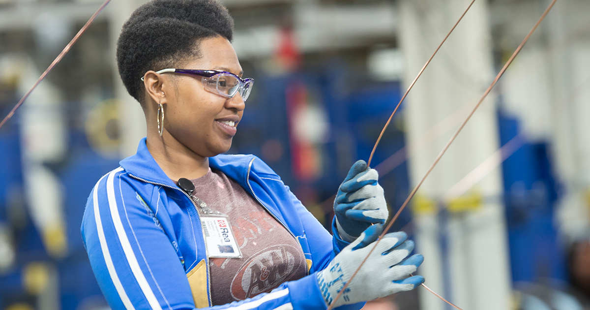 woman wearing safety goggles and gloves at Rea Magnet Wire