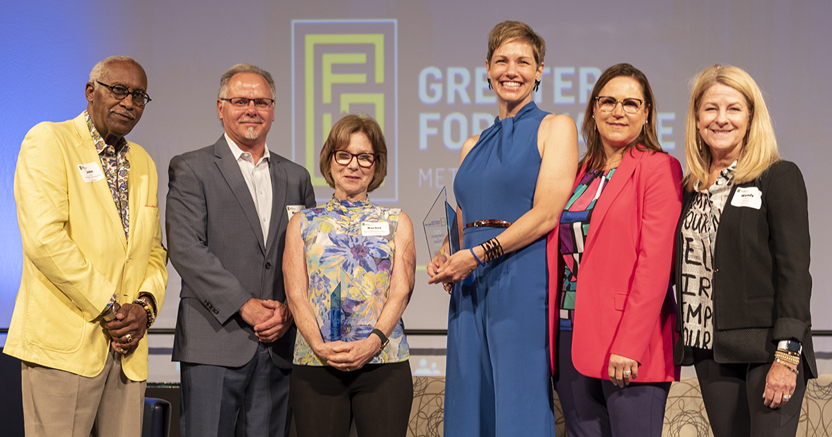 Rachel Tobin-Smith and Leslee Hill pose for photos after winning the 2021 Champions of Change awards alongside past winners