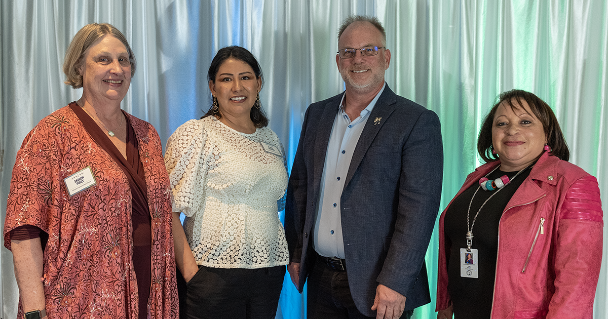 Sharon Pohly, Flora Barrón, Daniel Boylan, and Lori Morgan pose on stage for a photo after receiving the 2023 Champions of Change Awards.