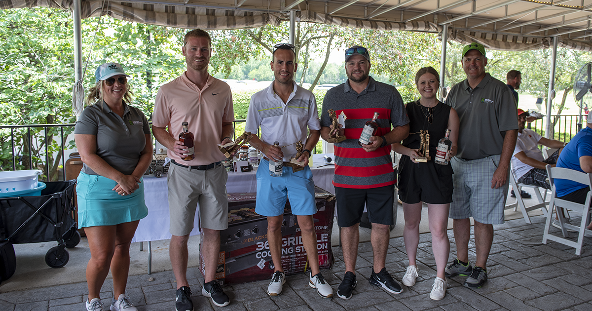 A team accepts its trophy after the Greater Golf Open