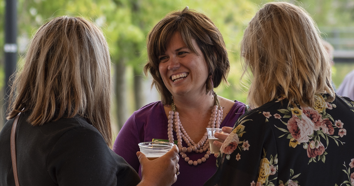 Three women have a conversation at a Meet Me at 5:05 networking event