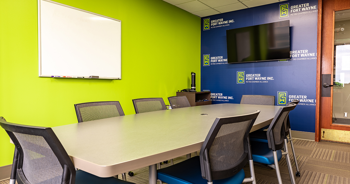 Photo of a table, chairs, dry-erase board, and TV in the Doermer East conference room