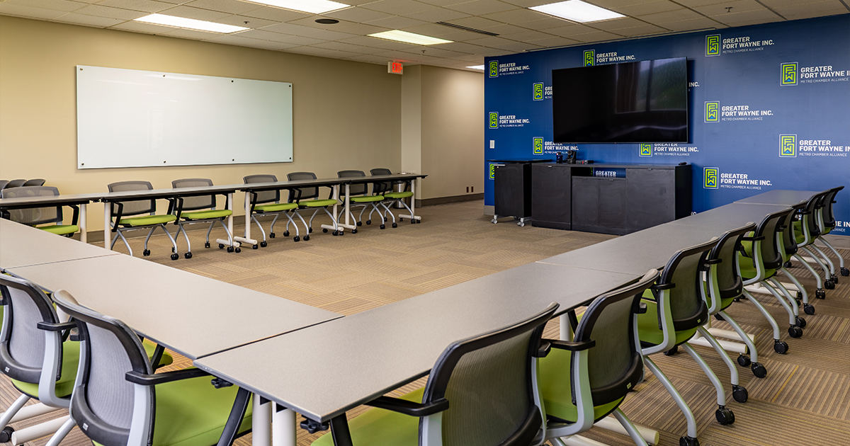 Photo of a tables, chairs, dry-erase board, and TV in the Greater Fort Wayne Inc. Main conference room